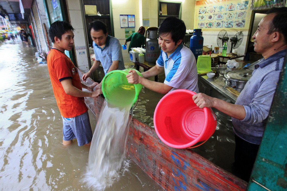 سكان يحاولون التخلص من مياه الفيضانات التي ضربت منطقة غوانغ دونغ جنوب الصين، 11 مايو/أيار