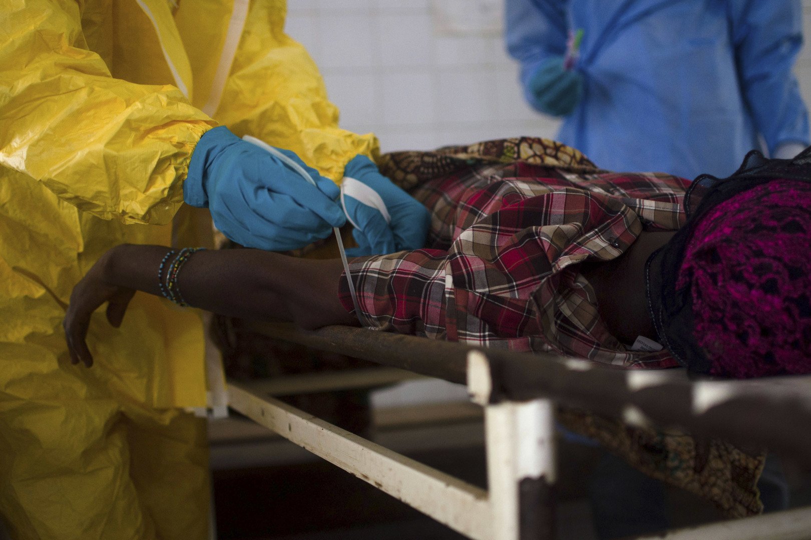 الأطباء يسحبون عينة دم من جسم مريض يشتيه إصابته بفيروس إيبولا في مدينة كينيما بسيراليون، 10 يوليو 