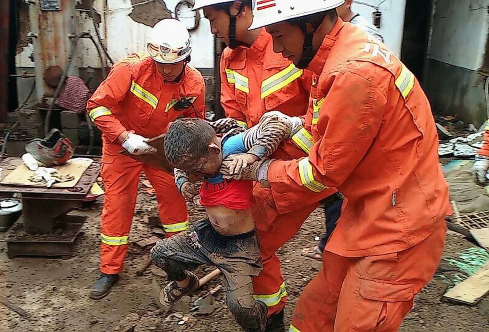 عمال الانقاذ يساعدون طفلا خرج من تحت أنقاض الزلزال الذي ضرب منطقة لونغ تاوشان بالصين، 4 أغسطس