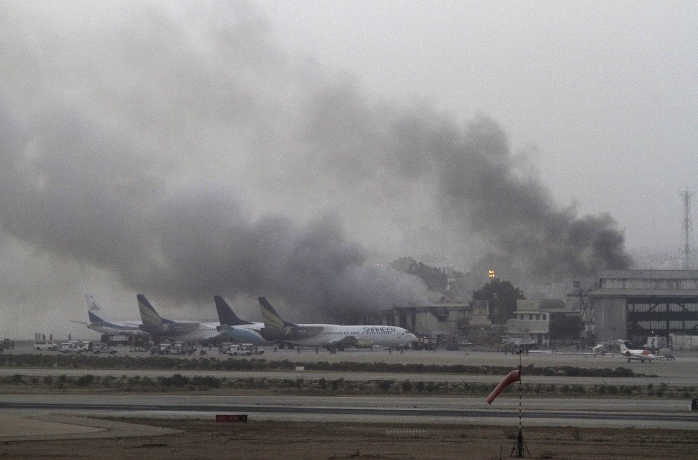 أعمدة الدخان تتصاعد من مطار جناح الدولي في كراتشي إثر تفجيرات إرهابية، باكستان، 9 يونيو/حزيران   