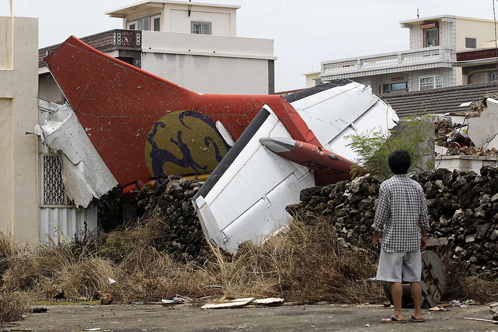 رجل يشاهد آثار طائرة ترانس آسيا التي تحطمت في جزيرة بينغو في تايوان، 24 يوليو/تموز 
