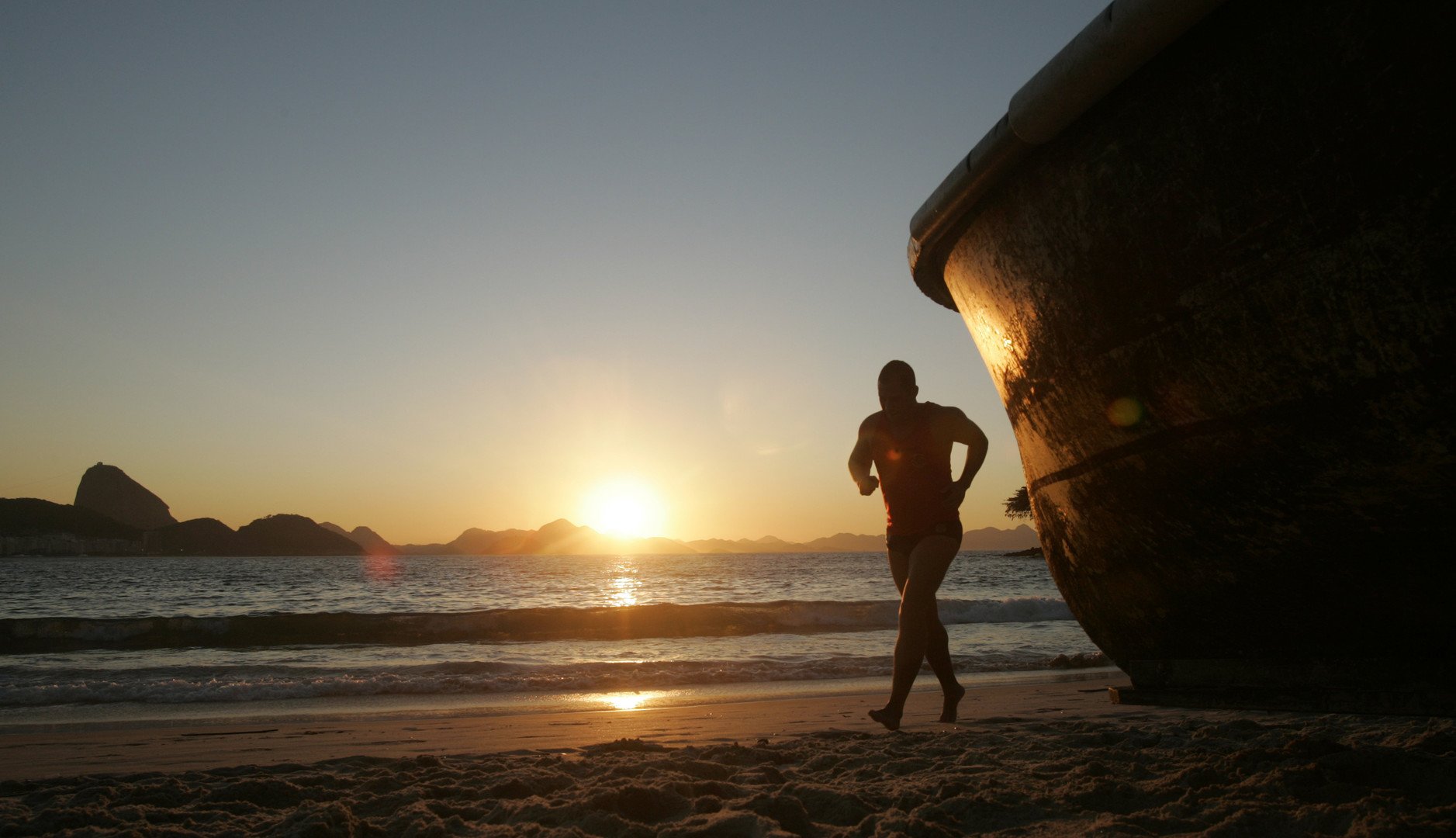  رجل يركض للتمتع بنسيم البحر على شاطئ كوبا كابانا مع شروق الشمس، ريودي جانيرو، البرازيل، 15/سبتمبر