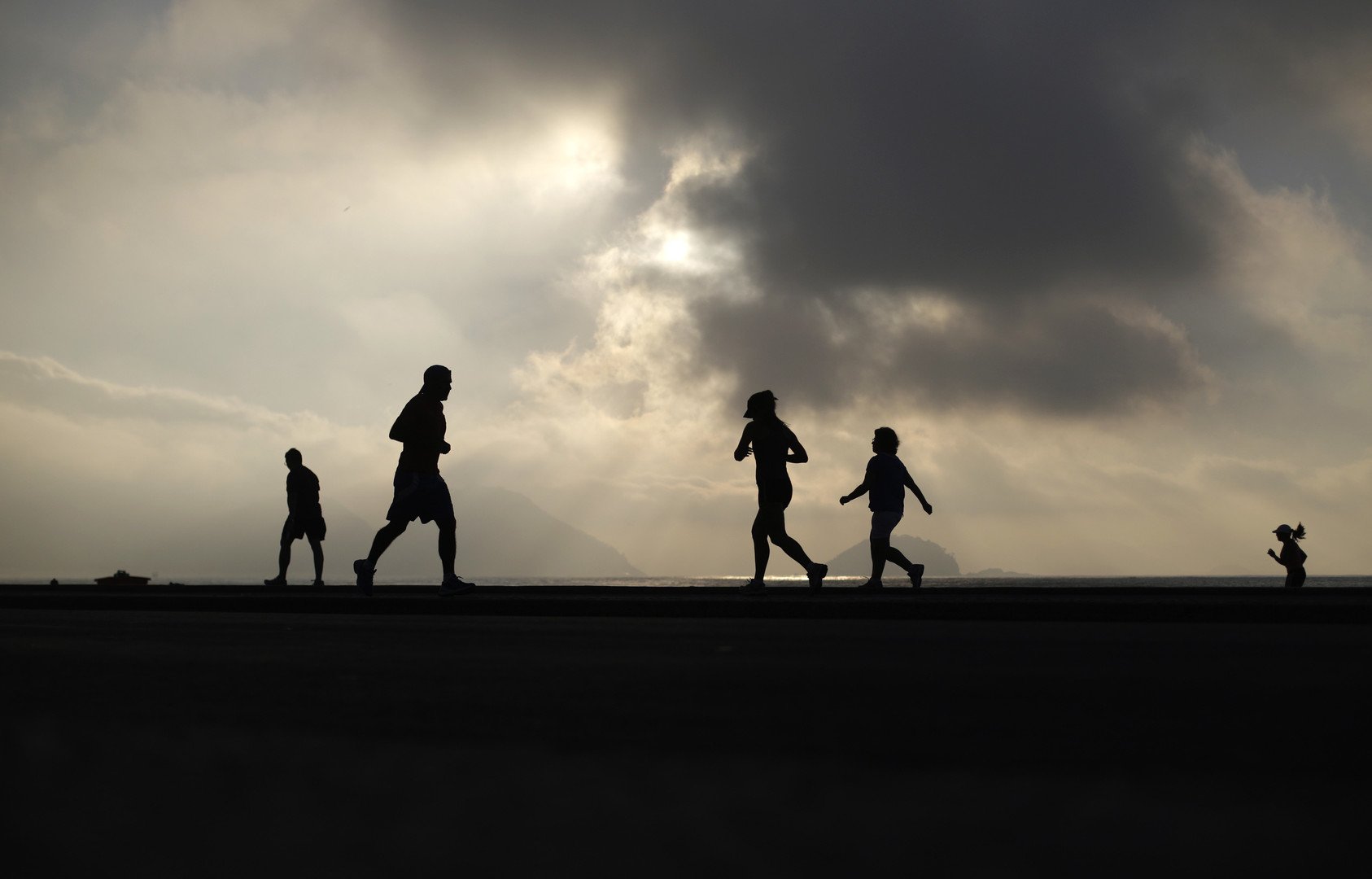 مصطافون يتمتعون بنسيم البحر أثناء ممارسة رياضة الجري على شاطئ كوبا كابانا، البرازيل، 5 يونيو/حزيران