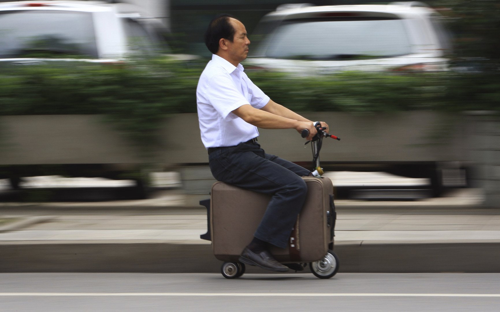 هي ليانغ يقود حقيبته اليدوية ذات المحرك المصنوعة يدويا في مقاطعة هونان الصينية، 28 مايو 2014