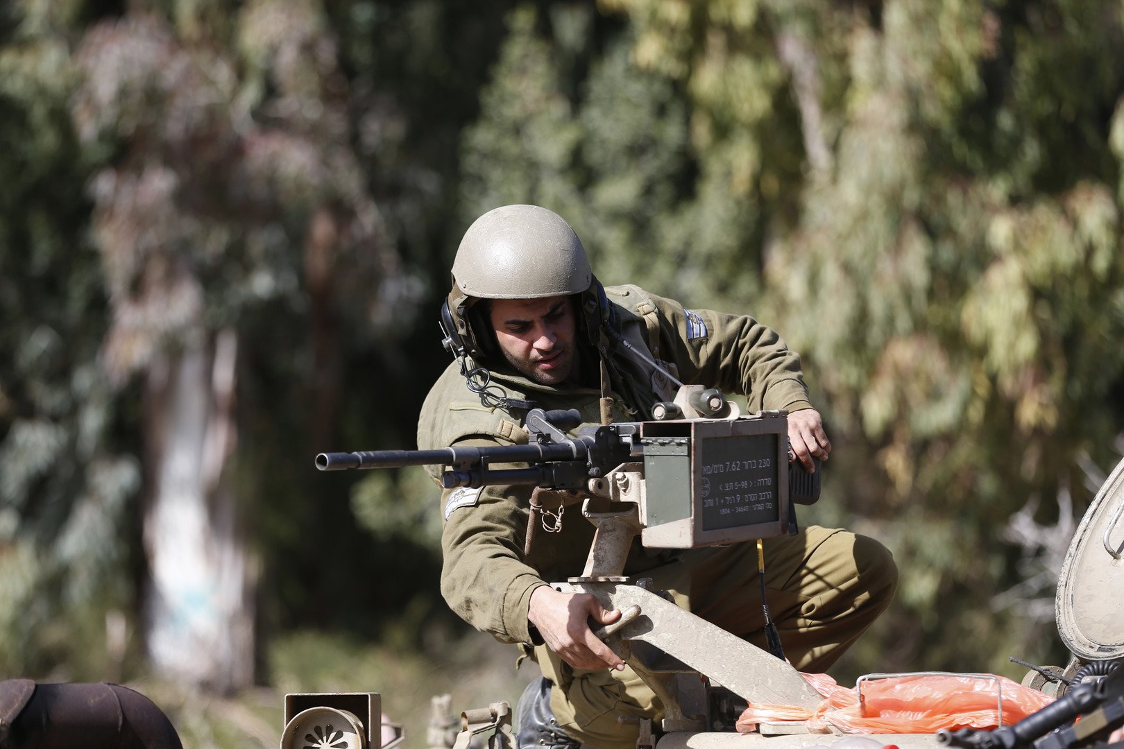 جندي اسرائيلي يُعدّل من وضعية سلاحه فوق مدرعته، على الحدود الاسرائيلية اللبنانية، 28 يناير 2015