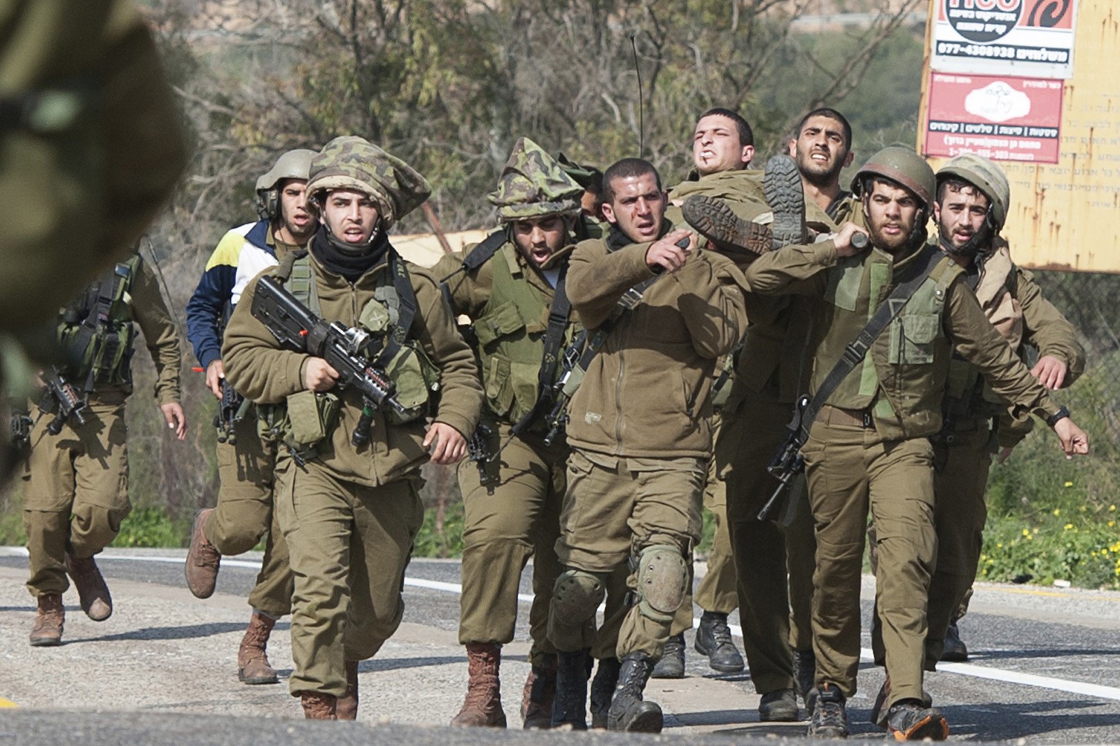  جنود اسرائيليون يحملون جنديا مصابا نتيجة قصف حزب الله على حدود اسرائيل مع لبنان، 28 يناير 2015