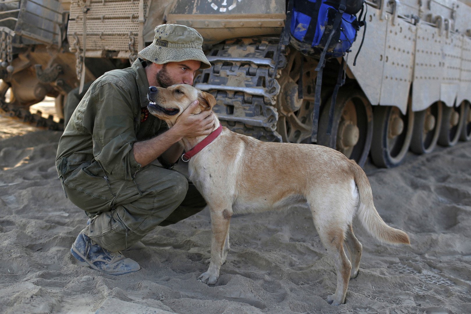 جندي اسرائيلي يقبل كلبا مدربا ، بالقرب من منطقة الحدود مع قطاع غزة، 3 أغسطس 2014