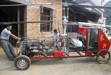 أهل القرية يحاولون مساعدة جيانغ شانغن في تحريك طائرته الهليكوبتر المصنوعة يدويا، 7 أغسطس/آب 2014