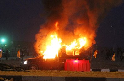  النيران تشتعل في إحدى سيارات الشرطة إثر اشتباكات قوات الأمن مع جماهير نادي الزمالك