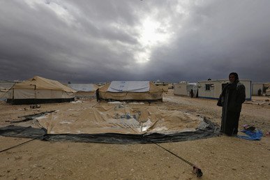 سيدة تقف أمام خيمتها التي أسقطتها عاصفة ثلجية داخل مخيم الزعتري، 8 يناير 2015 