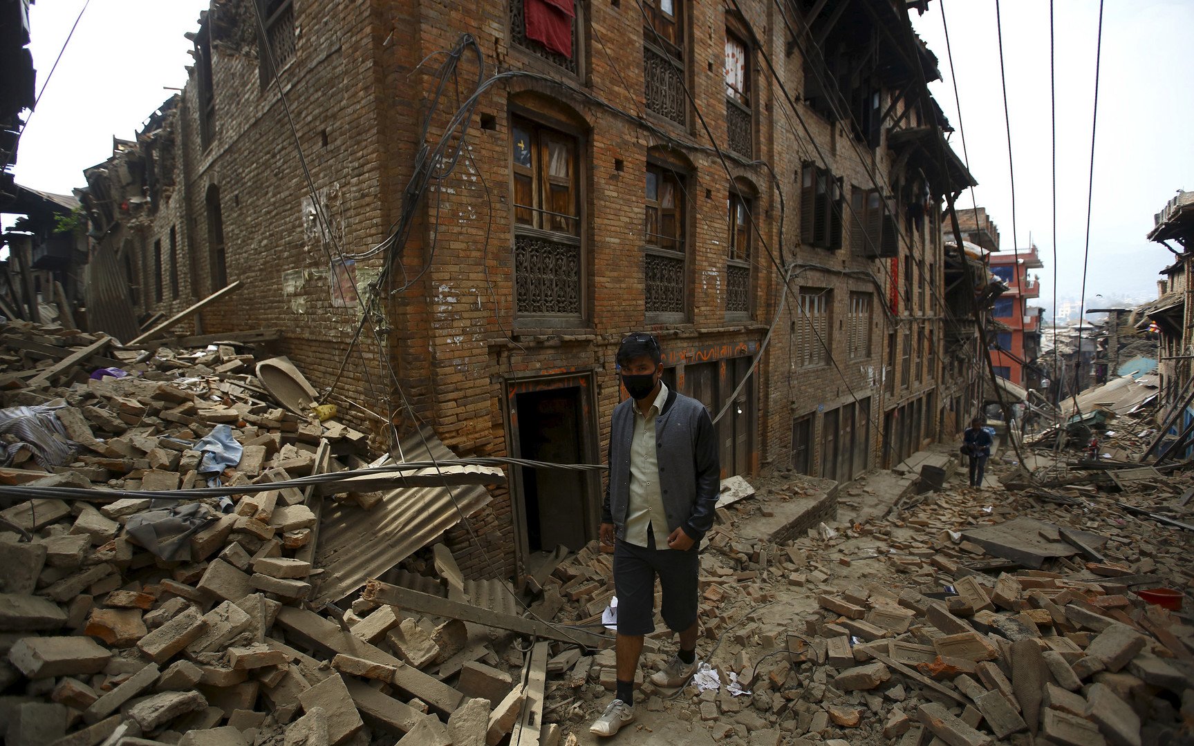 رجل يسير بين انقاض المنازل المهدمة بعد يوم من الزلزال