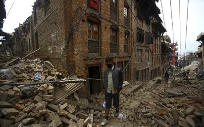 رجل يسير بين انقاض المنازل المهدمة بعد يوم من الزلزال