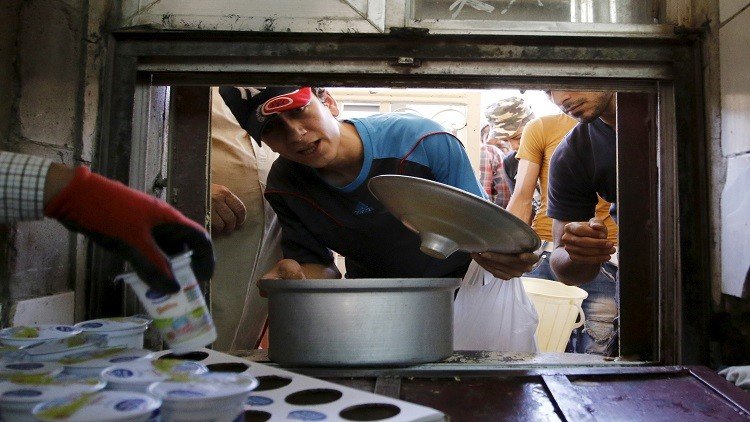  رجل يحصل على طعام مجاني يوزع للمحتاجين خلال شهر رمضان بمسجد في بغداد