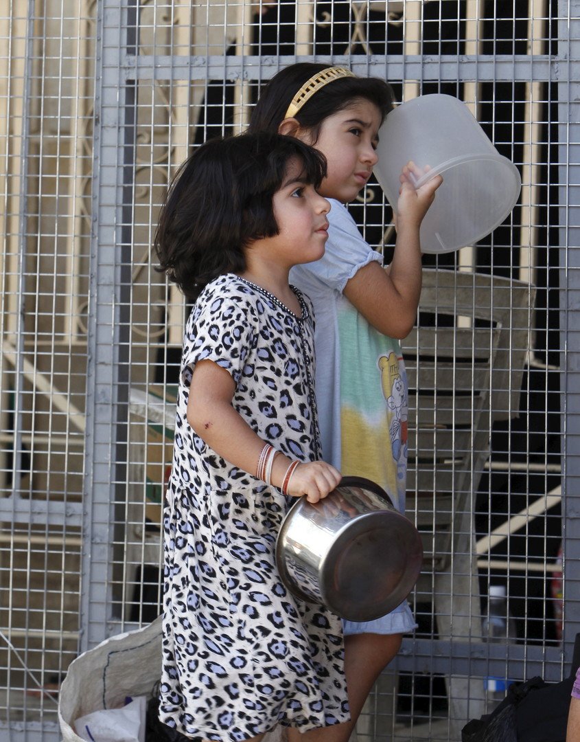 فتيات ينتظرن الطعام المجاني الذي يوزع على المحتاجين في مسجد عبد القادر الكيلاني في بغداد