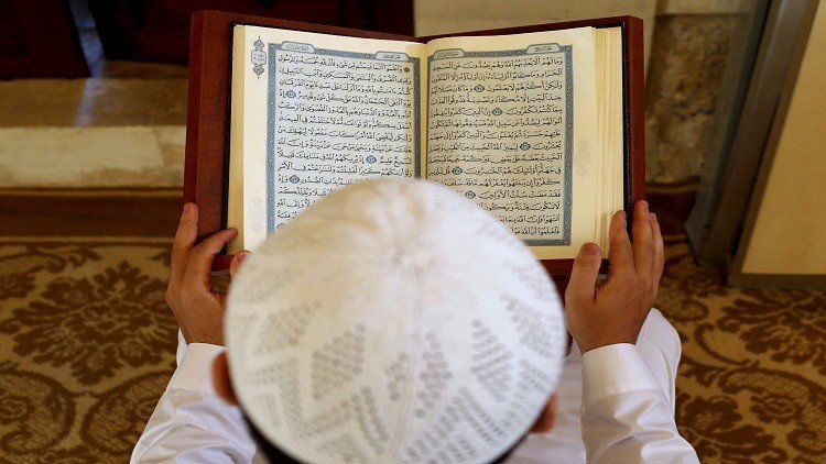  رجل يتلو القرآن أثناء الصلاة داخل مسجد في بيروت خلال شهر رمضان