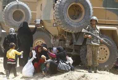  جندي تركي أثناء الخدمة بينما ينتظر السوريون وسائل تنقلهم إلى داخل تركيا، 10 يونيو 2015