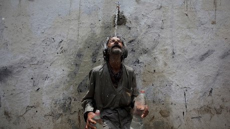 رجل يخفف وطأة الحر عليه بمياه صنبور عمومي ، كراتشي، 23 يونيو/حزيران