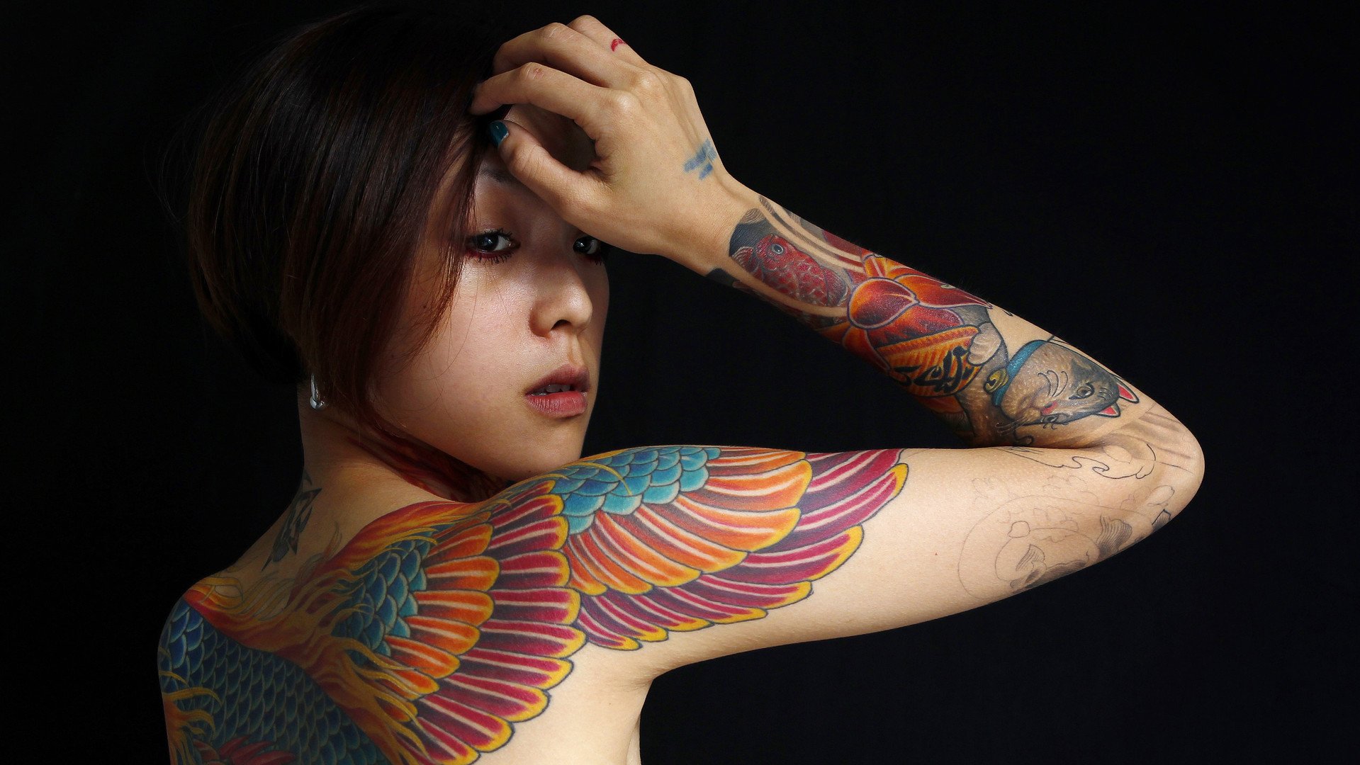 عارضة الوشوم "ناي" زوجة فنان رسم للوشوم من تايوان تستعد للتصوير خلال مهرجان الوشم الدولي في تايوان، 31 يوليو/تموز 2010    