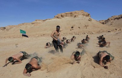 متطوعون عراقيون يتلقون تدريبات على الزحف في صحراء النجف