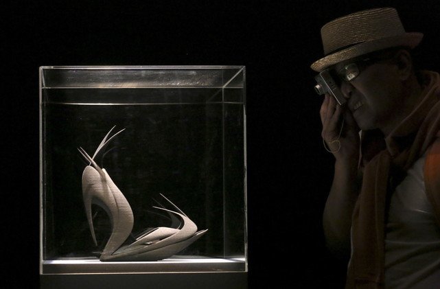 زائر يأخذ صورة من حذاء مصنوع باستعمال آلة طابعة ثلاثية الأبعاد وقد صمم الحذاء المهندس المعماري زها حديد خلال أسبوع التصميم في ميلانو، 16 أبريل/نيسان 2015.