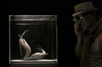 زائر يأخذ صورة من حذاء مصنوع باستعمال آلة طابعة ثلاثية الأبعاد وقد صمم الحذاء المهندس المعماري زها حديد خلال أسبوع التصميم في ميلانو، 16 أبريل/نيسان 2015.