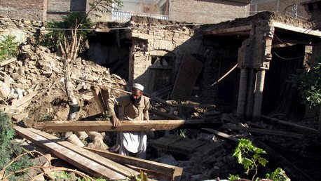 رجل يحاول رفع الحطام الناتج عن الزلزال العنيف من أمام منزله، باكستان، 27 أكتوبر/تشرين الأول 2015 