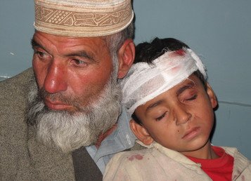 رجل يحمل طفله المصاب جرّاء الزلزال العنيف في  باكستان (26 أكتوبر/تشرين الأول 2015)