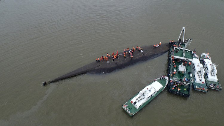 أفراد من فرقة الإنقاذ أثناء بحثهم عن سفينة غرقت في نهر في الصين