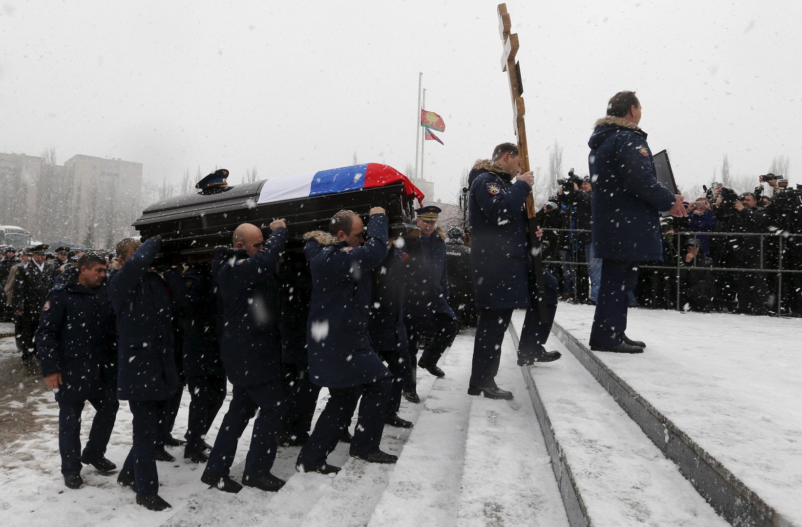 طيارون روس يحملون التابوت الذي يضم جثمان أوليغ بيشكوف في أثناء تشييع جنازته في مدينة ليبيتسك