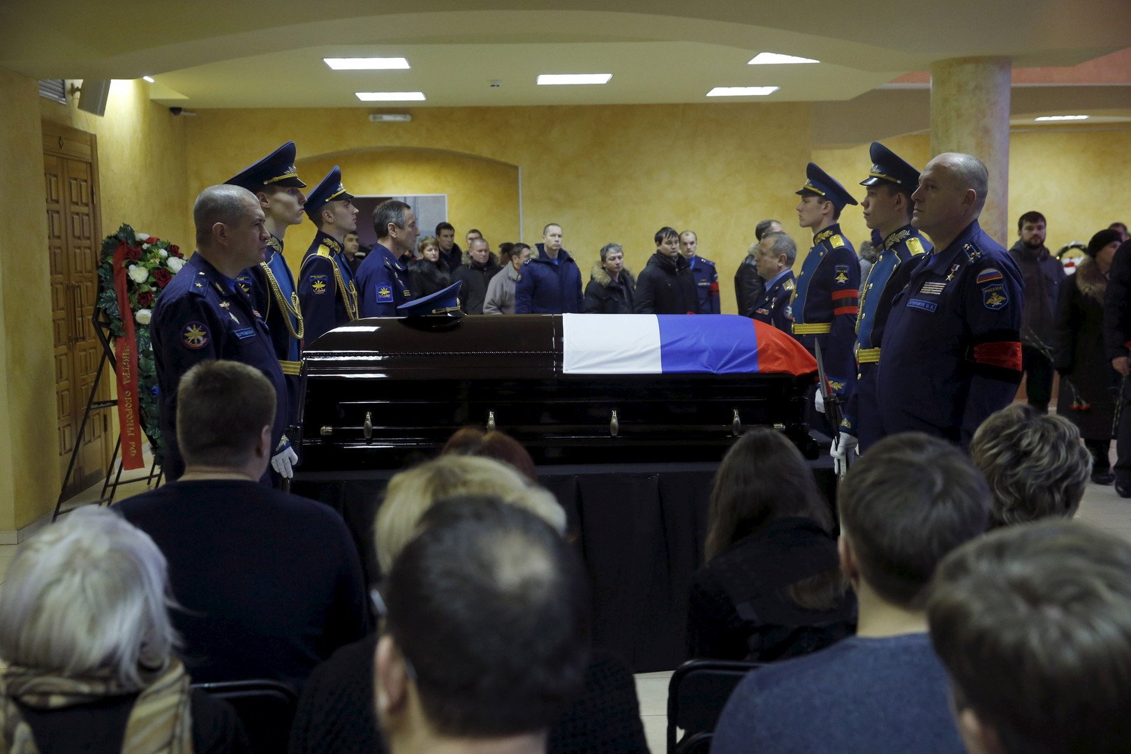 أشخاص يمرون بجانب التابوت مودعين الميت أوليغ بيشكوف الذي أسقطت طائرته في سوريا