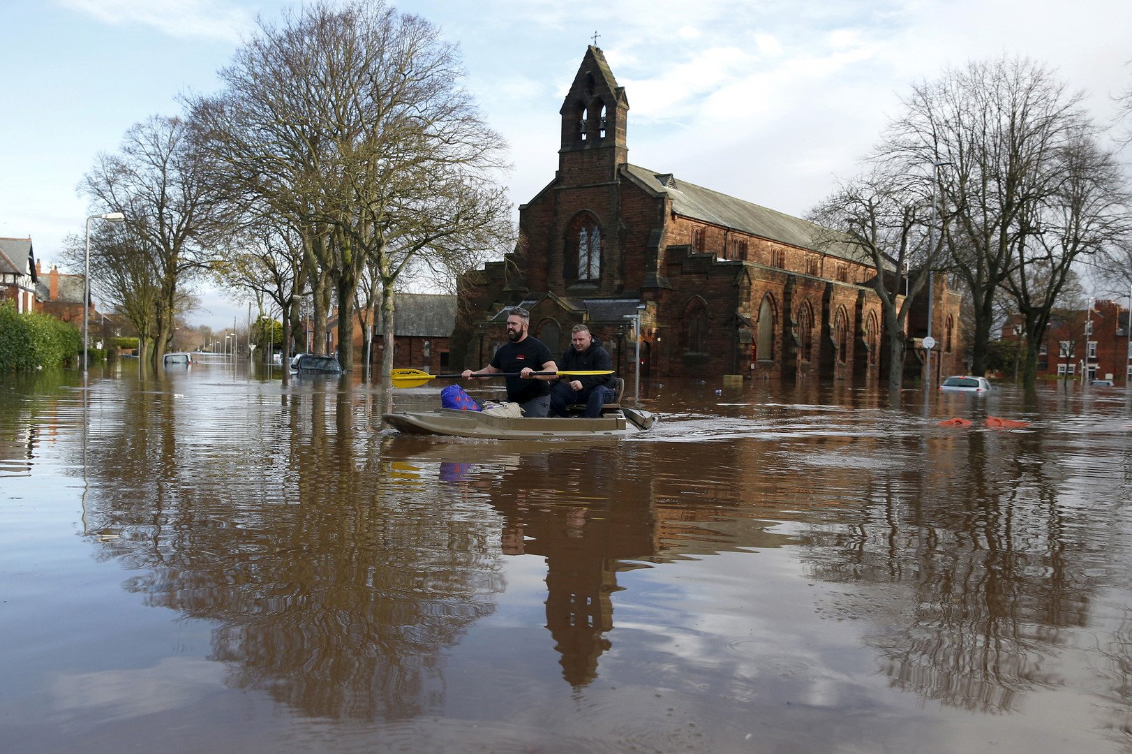 صورة للسكان المحليين على متن قوارب صغيرة وسط الشوارع التي غمرتها مياه الفيضانات في مدينة كارليل البريطانية، 6 ديسمبر/كانون الأول
