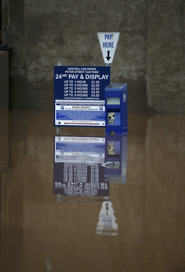 مياه الفيضانات غمرت ماكينة لدفع النقود مقابل توقف السيارات في مدينة كارليل الانجليزية، شمال غرب انجلترا، 7 ديسمبر/كانون الأول