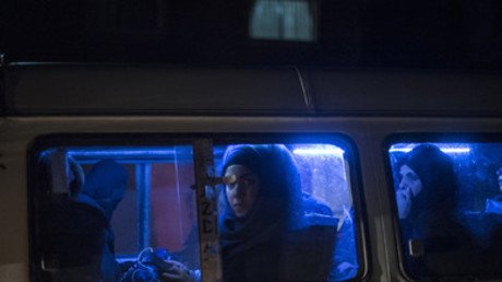 امرأة تركب حافلة تسير في شارع دمشقي