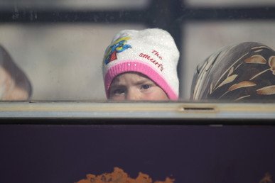 طفل ينظر من نافذة حافلة خلال عملية إجلاء المقاتلين والمدنيين من اثنتين من البلدات المحاصرة، الفوعة وكفريا، في ريف إدلب، في الطريق للعبور إلى تركيا من معبر الحدود السورية التركية باب الهوى.