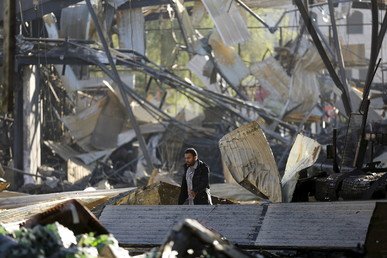 عامل يتفقد أضرار مصنع المشروبات كوكا كولا، بعد أن دمرته الغارات الجوية السعودية، صنعاء، اليمن