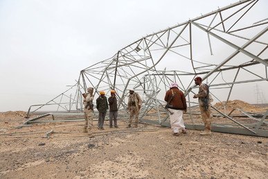 جنود موالون للحكومة اليمنية وأعضاء فريق هندسي يقفون بجوار أبراج نقل الطاقة الكهربائية التي دُمرت خلال عملية بحث عن الألغام الأرضية، والتي تركها المتمردون الحوثيون في منطقة ماس، الخاضعة لسيطرة الجيش الموالي للحكومة اليمنية، مأرب