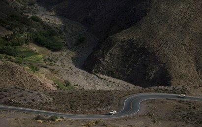 سائق برتغالي يقود سيارته أمام سائق من تشيلي وهما في طريقهما إلى خط الانطلاق في المرحلة الرابعة من سباق دكار