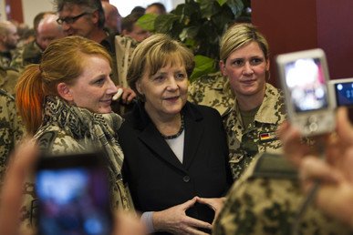 أنجيلا ميركل في أثناء التقاط صورة مع عسكريتين ألمانيتين