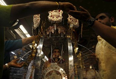 نصير هندوسي ينتظر انتهاء ترتيب زيه التقليدي في أثناء فعاليات المهرجان في سنغافورة