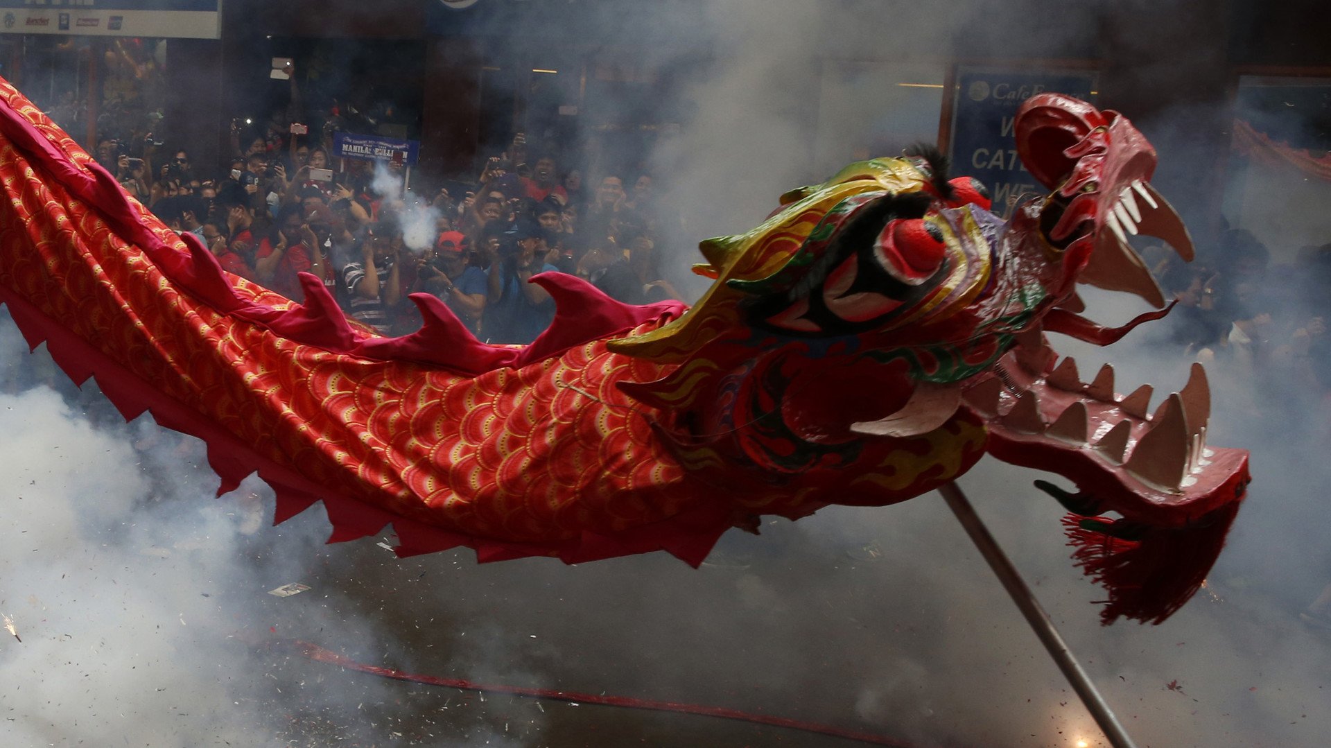 أشخاص يطلقون سهاماً نارية بجانب تنين راقص في مانيلا