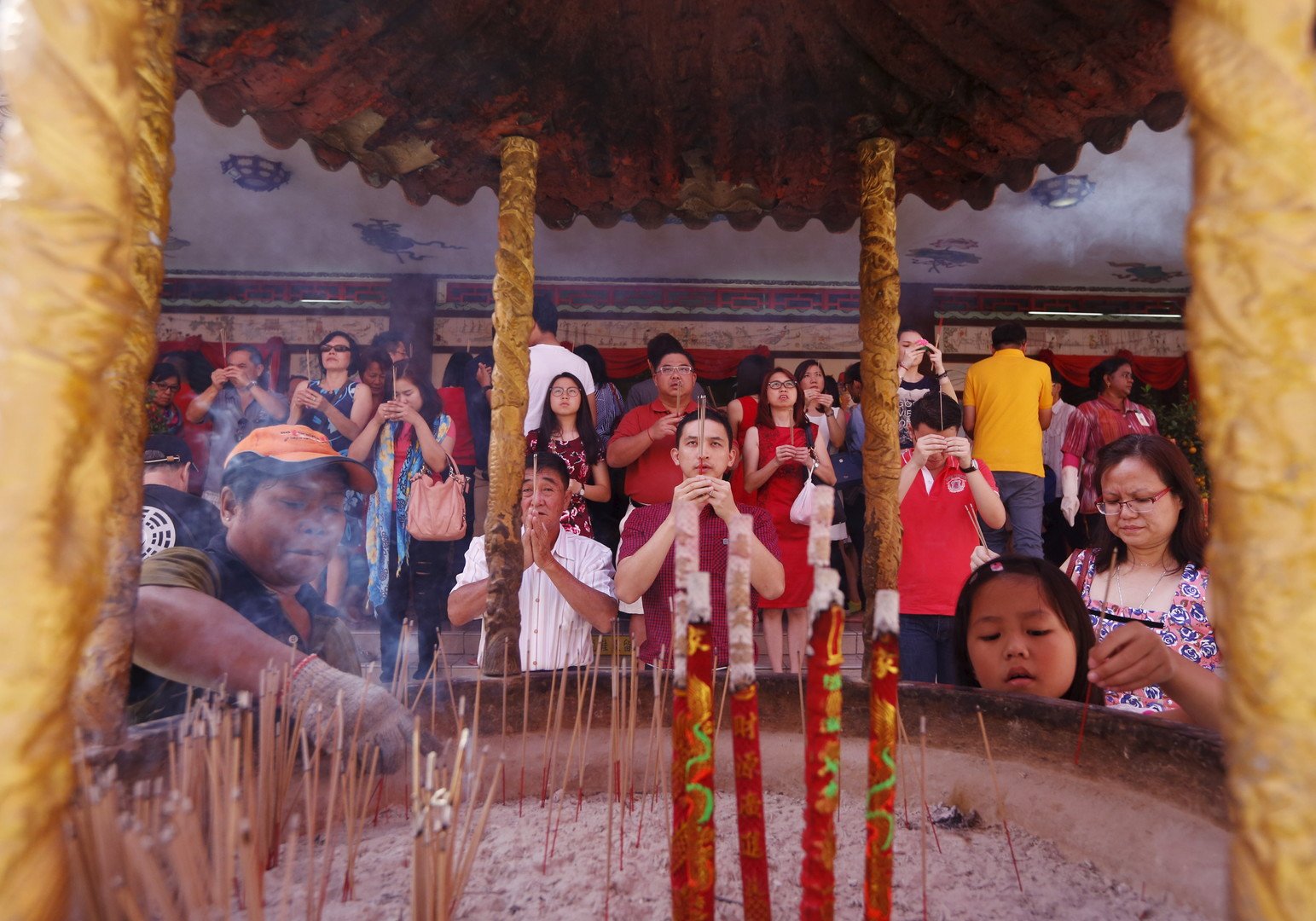 مؤمنون يؤدون فروض الصلاة في معبد في أثناء الاحتفال بعيد رأس السنة الصيني في تايلاند