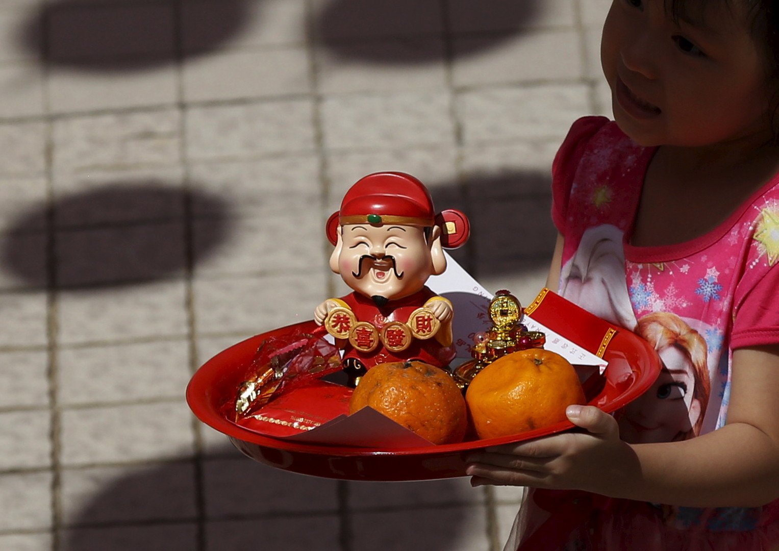 طفل يقدم هدية إلى أحد المعابد بمناسبة عيد رأس السنة الصيني في ماليزيا