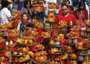 مؤمنون يؤدون فروض الصلاة في معبد في أثناء الاحتفال بعيد رأس السنة الصيني في ماليزيا