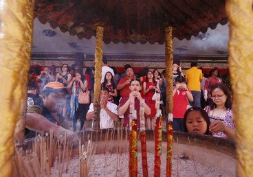 مؤمنون يؤدون فروض الصلاة في معبد في أثناء الاحتفال بعيد رأس السنة الصيني في تايلاند