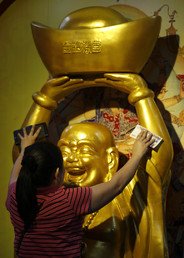 امرأة تصلي في معبد في تايلاند في أثناء الاحتفال بعيد رأس السنة حسب التقويم الصيني