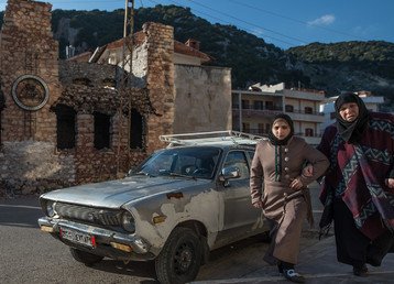 امرأتان تمشيان في أحد الشوارع في مدينة كسب الواقعة بالقرب من الحدود السورية التركية