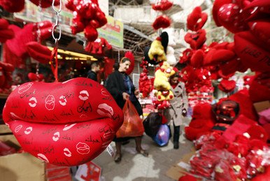 سيدة عراقية تتسوق داخل محل يعرض دمية الدب الشقي والوسادات الحمراء احتفالا بحلول مناسبة عيد الحب، منطقة الكرادة، 14 فبراير/شباط 2015  