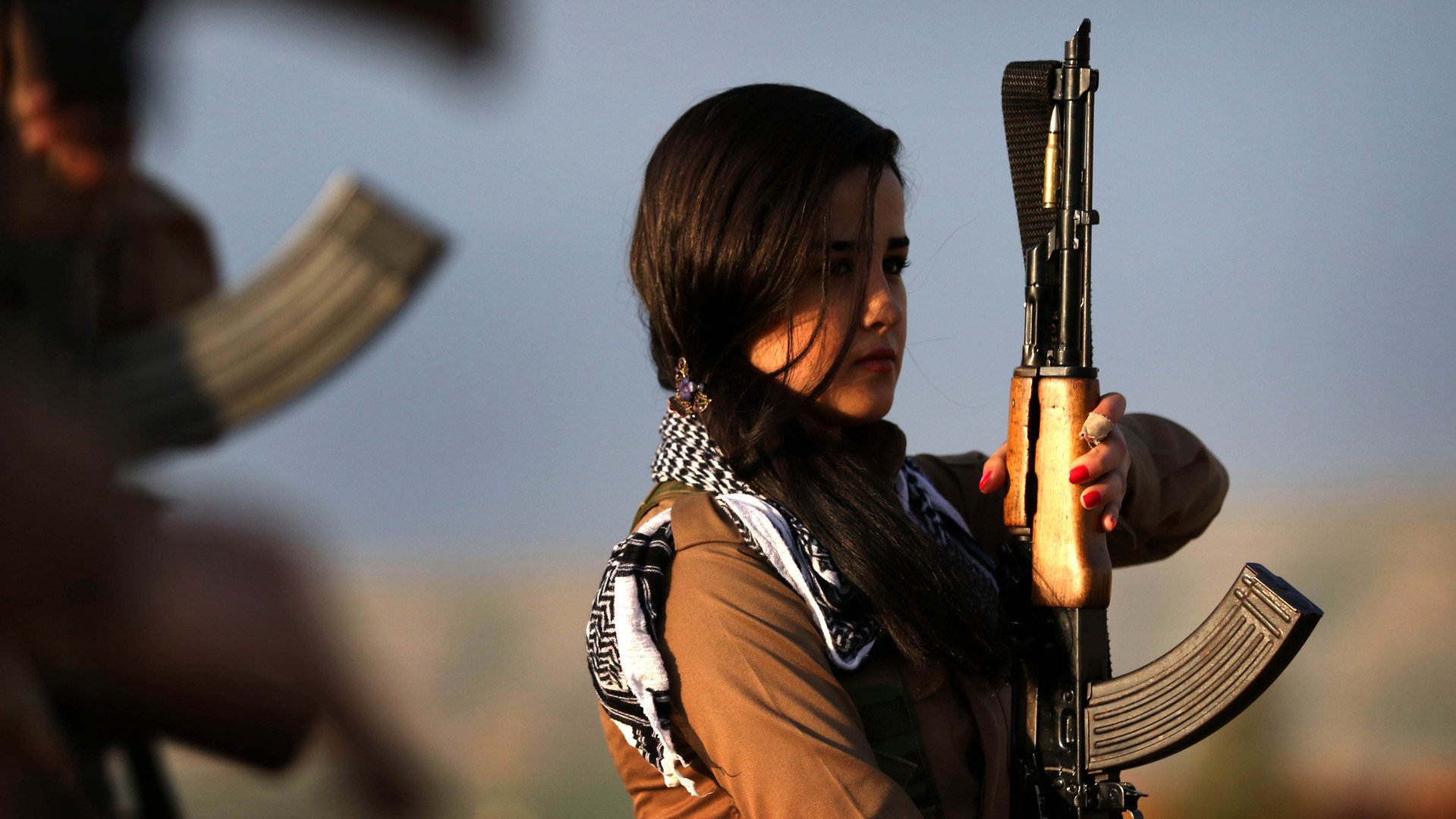 فتاة من أكراد إيران في الحزب الديمقراطي الكردستاني ، تستعرض سلاحها خلال مشاركتها في دورة تدريبية قبل عيد النوروز (رأس السنة الفارسية) في بلدة كويه، 100 كم شمال أربيل.