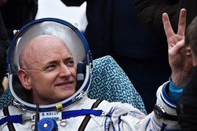 رائد الفضاء الأمريكي سكوت كيلي يرسم بإصبعيه علامة النصر بعد وقت وجيز من هبوطه إلى الأرض يالقرب من مدينة جيزكازغان في كازاخستان