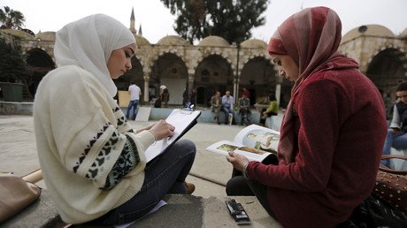 فتاتان إحداهما ترسم والثانية تطالع في مجمع التكية - السليمانية